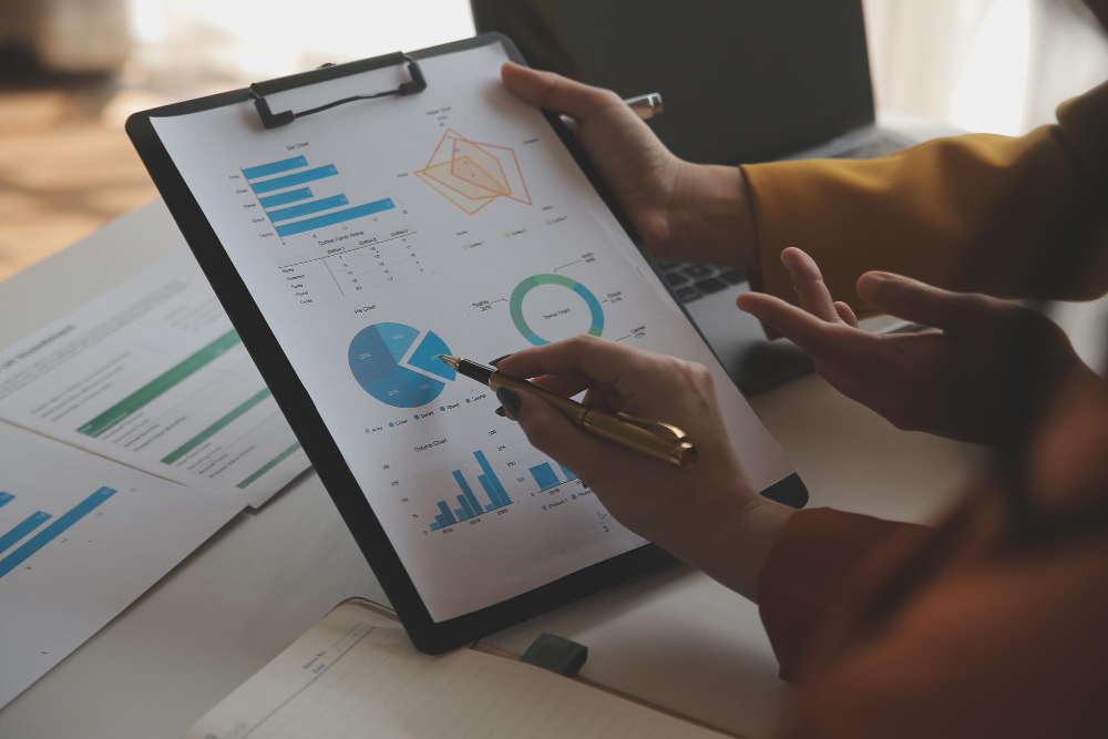 Análise de gráficos e documentos durante uma reunião.